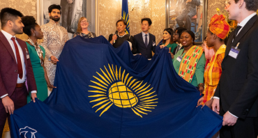 Commonwealth Secretary-General and youth leaders holding the Commonwealth flag