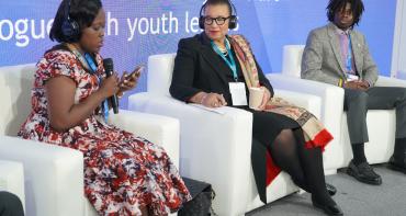 Secretary General and two youth leaders sat on stage