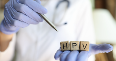 Hand with doctors gloves holding HPV wooden letters