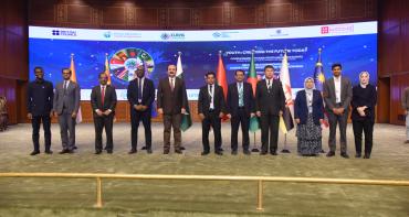 11 people standing on a stage