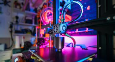 A 3D printer with a printed object on the worktop, in a home workshop. Photographer: Jakub Żerdzicki