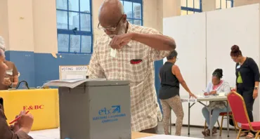 A man places his vote in the ballot the box during Trinidad and Tobago's 2025 Parliamentary Elections