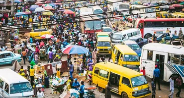 Busy market place with busses and cars