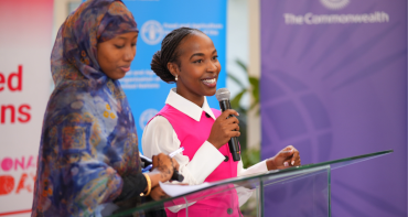 Two women stand together in front of a podium