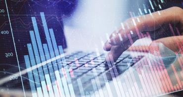 Financial market chart with someone typing on a laptop