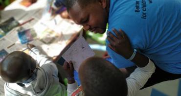 Sidney Chahonyo with two children during an art therapy workshop in a hospital