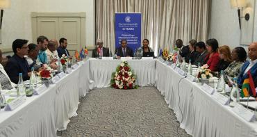 People sitting around the table for a Commonwealth Climate Finance Access Hub Steering Committee meeting with a banner in the background 
