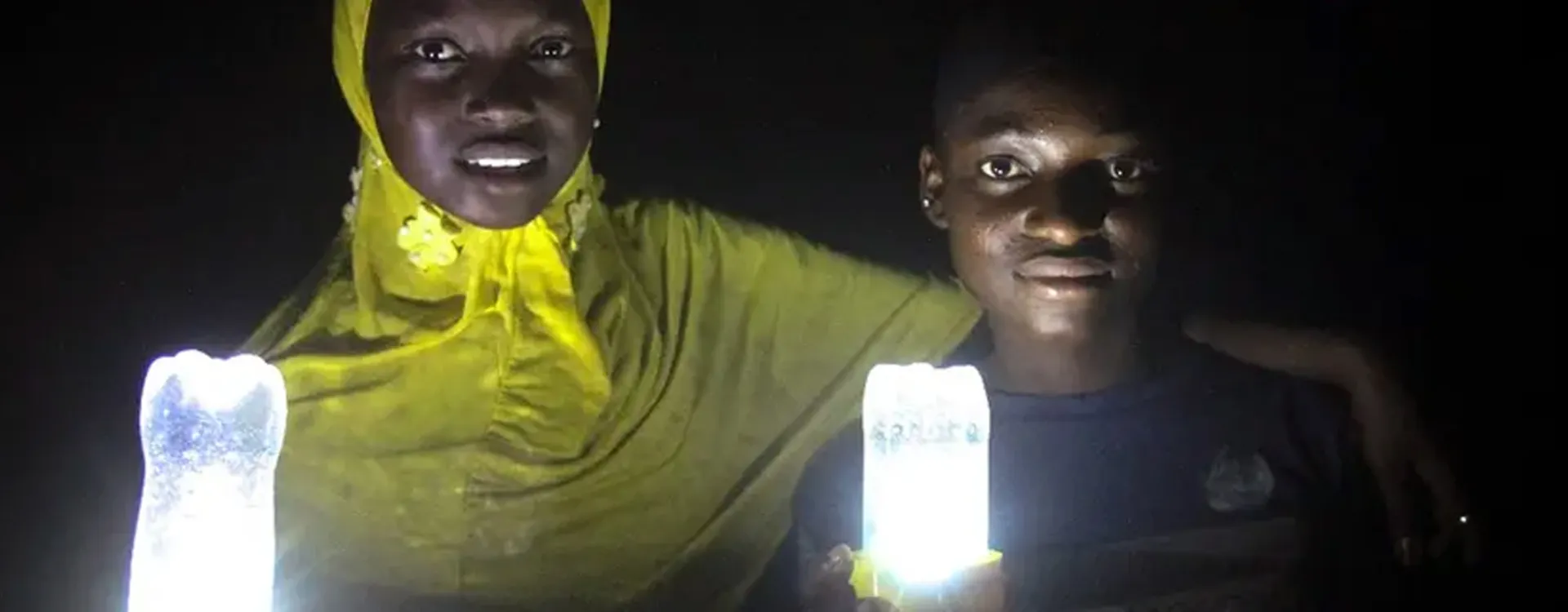 two Nigerian girls with solar lamps