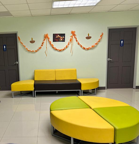 A waiting area with brightly coloured yellow and green soft seating